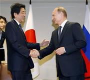 ロシアのウラジーミル・プーチン大統領（右）と握手する安倍晋三（しんぞう）首相＝２０１５年９月２８日、米ニューヨークの国連本部（共同）