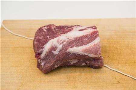 ゆで豚（豚の縛り方１）＿＿肉の下にたこ糸を斜めに敷く（松下二郎さん撮影、提供写真）