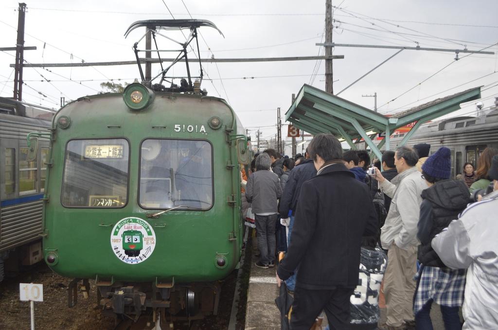 大勢の鉄道ファンが待ち構える中、北熊本駅のホームに到着した「青ガエル」＝熊本市北区（谷田智恒撮影）