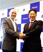 握手を交わすみずほフィナンシャルグループの阿部展久氏（右）とマネーツリーのポール・チャップマン社長＝２３日、東京都千代田区（米沢文撮影）