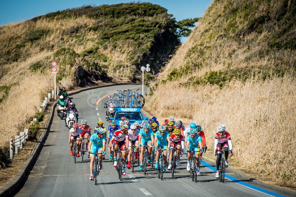 男子ジュニアロードレース。海岸線沿いのアップダウンに富む区間を走る選手たち。ディンムハメッド・ウリスバエブ（カザフスタン）が優勝。３位に花田聖誠（昭和第一学園）＝２０１６年１月下旬、東京都大島町（田中苑子さん撮影）