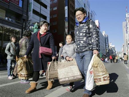 たくさんの荷物を手に東京・銀座の街を歩く中国人観光客