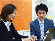 社内で同僚と打ち合わせをする明智カイトさん（右）＝１月、東京都千代田区