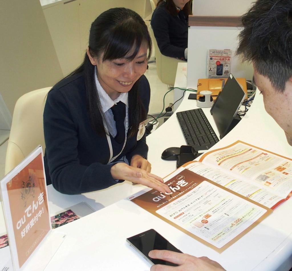 ＫＤＤＩの「ａｕでんき」を勧めるａｕショップ店員＝東京都新宿区