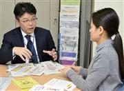 国立がん研究センター中央病院の相談支援センターで、ソーシャルワーカー（右）と打ち合わせをするハローワークの職員＝東京都中央区