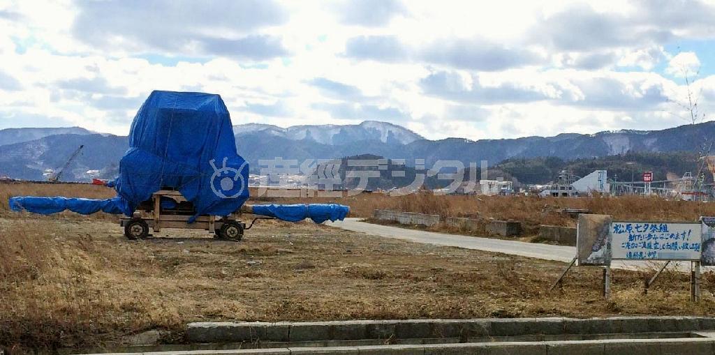 かつての住民に呼びかけるため、中里哲さんが設置した看板と、七夕祭りの山車＝２０１４年２月２３日、岩手県陸前高田市（看板の電話番号にモザイク加工しています）