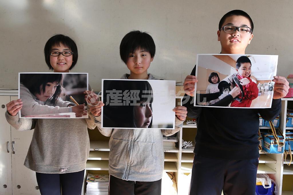 震災直後の始業式で撮影した写真を手にする岩手県陸前高田市立高田小学校６年生の（写真左から）金野彩芽（こんの・あやめ）さん、馬場友夢（ゆうゆ）さん、船砥大（ふなと・だい）君＝２０１６年１月２１日（大西正純撮影）