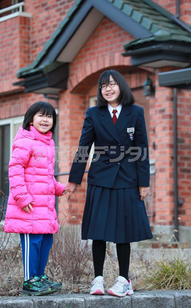 宮原伶奈さんと妹の杏奈さんは、自宅前で仲良く手を繋いでポーズを取ってくれた＝２０１６年２月１日、宮城県仙台市青葉区（鈴木健児撮影）