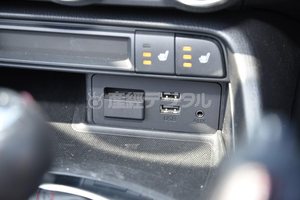 今どきのクルマらしく、ＵＳＢのジャックを２つ装備。ハンズフリー通話、音楽データ再生などに対応。左側の蓋の中にはナビ用メモリカードスロット。少しぼやけて上に写っているのはシートヒーターのスイッチとインジケーター。マツダロードスター