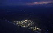 東日本大震災から５年を迎える東京電力福島第１原発。廃炉に向けた作業が続き日没後、敷地がライトで照らされていた。周辺の町は避難区域に指定されたままで暗闇が広がる＝２０１６年３月１０日午後６時６分（共同通信社機から撮影）