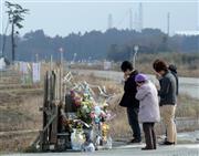 原発事故で全町避難が続く福島県双葉郡浪江町請戸地区で、地震発生時刻の午後２時４６分に慰霊碑前で手を合わせる人たち＝２０１６年３月１１日午後（鴨川一也撮影）