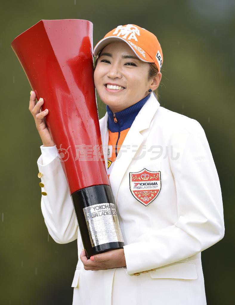 プレーオフを制し今季初勝利を挙げ、トロフィーを手に笑顔のイ・ボミ＝２０１６年３月１３日、高知県香南市の土佐ＣＣ（共同）