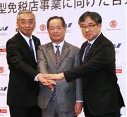 「市中空港型免税店」事業への参入を表明し手を合わせる高島屋の木本茂社長（中央）ら＝１６日、東京都港区