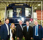 マイアミの日立製作所の鉄道車両工場で、車両の実物大模型の前に立つ日立の正井健太郎・交通システム社社長（右から２人目）ら＝１６日（共同）