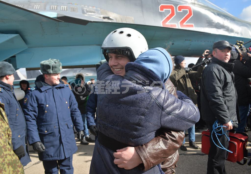 ３月１５日、シリアからロシア南部の基地に帰還し、家族と抱き合うロシア空軍パイロット＝２０１６年（タス＝共同）
