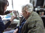 訪問看護師（左）が持ってきたタブレット端末のテレビ電話で主治医と話す藤沢昭さん＝１日、高松市内