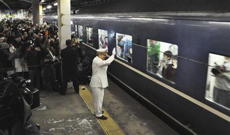 鉄道ファンとともに、急行はまなすの上り最終列車を見送る札幌駅長＝２０日午後、ＪＲ札幌駅