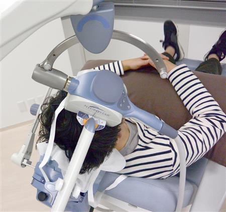 リクライニングシートに座り、ＴＭＳ治療を受ける男性