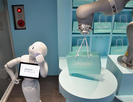 購入した製品を引き渡すロボット。左は接客を担当する人型ロボット「Ｐｅｐｐｅｒ」＝２４日、東京都港区