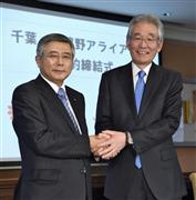 包括提携契約を結び、握手する千葉銀行の佐久間英利頭取（左）と武蔵野銀行の加藤喜久雄頭取＝２５日午後、東京都内のホテル