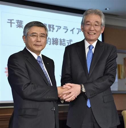 包括提携契約を結び、握手する千葉銀行の佐久間英利頭取（左）と武蔵野銀行の加藤喜久雄頭取＝２５日午後、東京都内のホテル