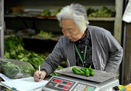 四川省成都市にある無人野菜販売所で野菜を購入する女性。中国でも「防犯意識が比較的弱い」などとみて高齢者を狙った悪徳業者が多くの事件を起こしているという（中国新聞社）