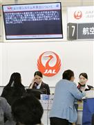 システム障害が発生し利用客に応対する、日航の職員ら＝１日午前９時５３分、大阪空港