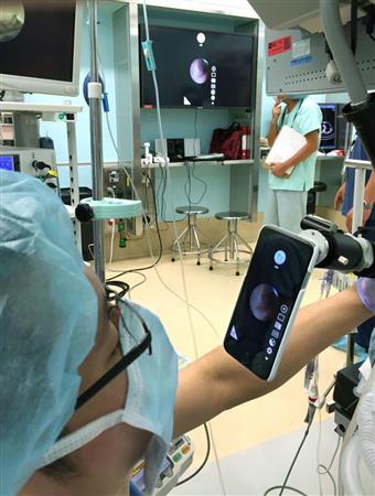 実際の手術で装置を使っている様子。奥の大型モニターにもｉＰｈｏｎｅと同じ画面が映っている（筑波大麻酔科の梅崎健司医師提供）