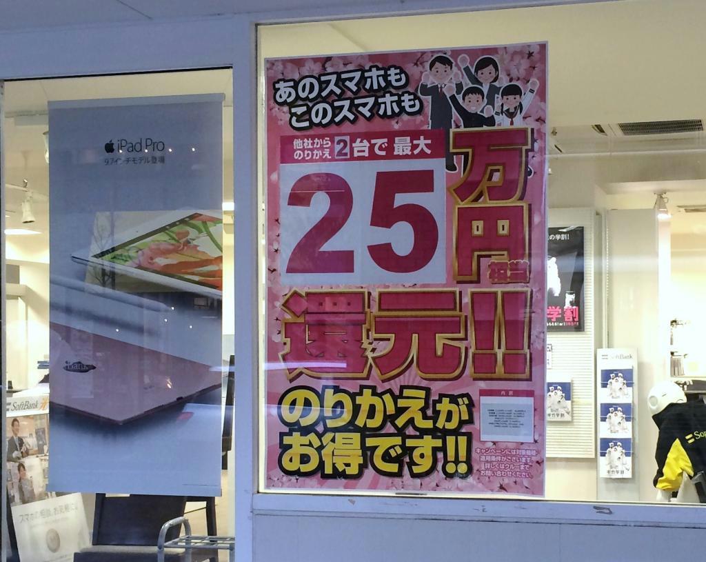 総務省の行政指導後も「実質０円」を下回る大幅値引きのポスターが張られた都内のソフトバンクショップ＝７日