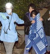 生後８カ月の美玖ちゃんが救出され、夫に支えられながら現場を離れる母親の西村亜沙美さん＝１５日午前３時４５分ごろ、熊本県益城町