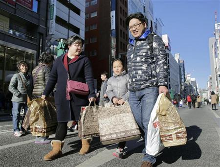 たくさんの荷物を手に東京・銀座の街を歩く中国人観光客