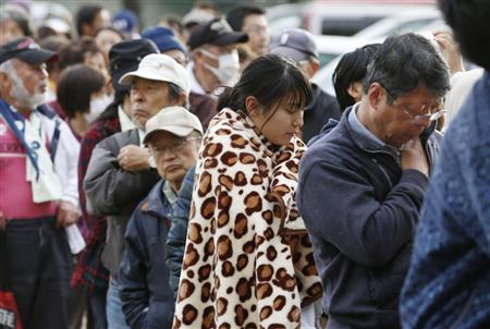 避難所となった小学校で、食料や水の配給の順番を待つ人たち＝１７日午前６時５１分、熊本県益城町