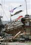 地震で倒壊した住宅の脇にたなびくこいのぼり＝１７日午前１１時、熊本県益城町