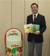 「じゃがりこ」のＰＯＰの横に立つ加藤孝一氏。立体器具は大量発注が常識だったが、１台からでも受注できるようにした