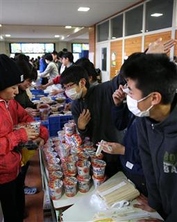 避難所で夕食を配る避難者の中学生（中央）ら＝１８日午後６時６分、熊本県益城町の広安小学校（鳥越瑞絵撮影）