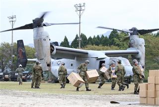 輸送支援を行う米軍の垂直離着陸輸送機オスプレイから物資を運ぶ自衛隊員ら＝１８日午後、熊本県南阿蘇村（福島範和撮影）