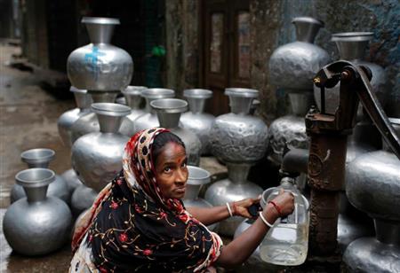 首都ダッカの路上で水をくむ女性。バングラデシュ政府は、７％台の成長を目指す（ＡＰ）