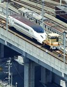 移送のためけん引用の車両に連結された、九州新幹線の先頭車両＝２２日午後１時１分、熊本市（共同通信社ヘリから）