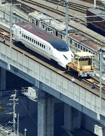 移送のためけん引用の車両に連結された、九州新幹線の先頭車両＝２２日午後１時１分、熊本市（共同通信社ヘリから）