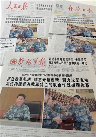 習近平国家主席が迷彩服姿で統合作戦指揮センターを視察したと１面トップで報じる２１日付の中国各紙（共同）