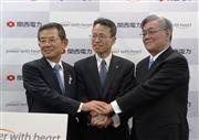 トップ交代を発表する会見で握手を交わす関西電力の森詳介会長、八木誠社長、岩根茂樹副社長＝３月２８日午後、大阪市北区