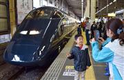 ＪＲ東日本の観光列車「現美新幹線」の車両と記念写真を撮る人＝２９日午前、ＪＲ越後湯沢駅