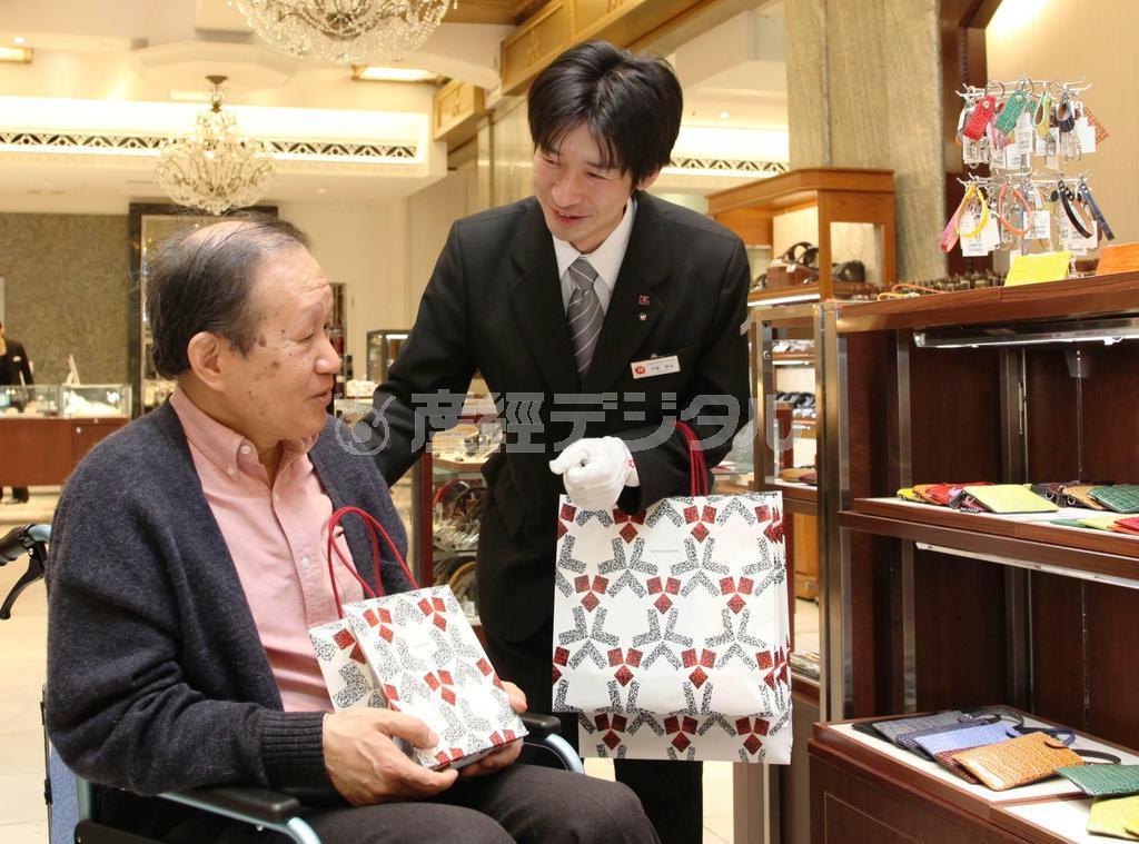 客の要望に合わせて百貨店での買い物に付き添う運転手（右）。購入した品物を自宅まで運ぶサービスも行う（日本交通提供）