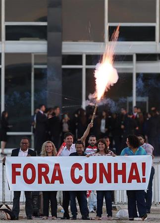 ルセフ大統領の弾劾を進めてきたクーニャ下院議長が議長職を剥奪されたことに関し、「クーニャは去れ」と書かれた横断幕を掲げる反クーニャ派の市民＝５日、ブラジリア（ロイター）