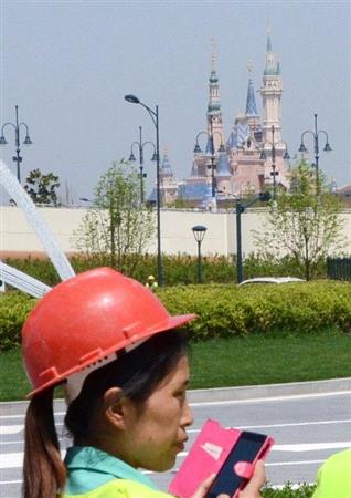 ６月１６日に開園予定の上海ディズニーランドと中国人労働者＝４月、中国・上海市（共同）