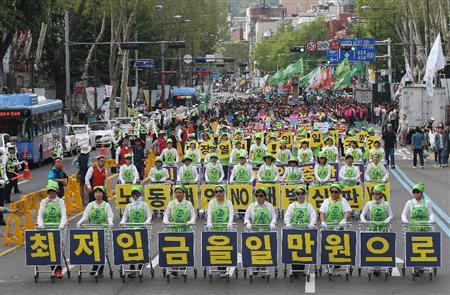 メーデーでショッピングカートにスローガンを掲げながら通りを行進する韓国の労働組合メンバー∥１日、ソウル市内（ＡＰ）