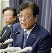 １１日、記者会見する三菱自動車の益子修会長。左は相川哲郎社長＝国交省
