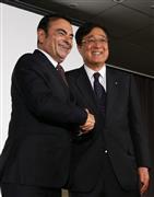 共同記者会見を終え握手をかわす日産自動車のゴーン社長（左）と三菱自動車の益子修会長＝１２日、横浜市（大西正純撮影）