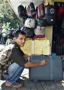 インドネシアの首都ジャカルタのスラバヤ通りで、中古スーツケースを磨くムハンマド・ユスフさん＝４月１日（共同）