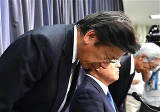 会見で辞任を発表した三菱自動車の相川哲郎社長（左）＝１８日午後、東京都千代田区の国土交通省